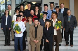 Absolventinnen und Absolventen mit Bachelor-Hut, eingerahmt von Studiengangsleiterin Susanne Kleibl,