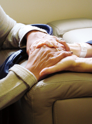 zwei alte Hände werden von zwei jungen Händen umfasst