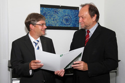 Professor Wolfgang Viöl (links) bekommt von Universitätspräsident Professor Thomas Ha