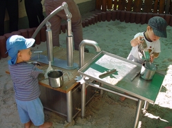 Konzentriertes Kinder-Kochen: Frederick (links) pumpt und matscht, w&auml;hrend Henry das Wasser von