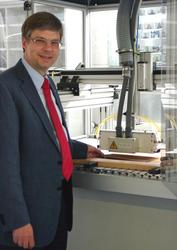 Prof. Viöl mit einer Plasmabeschichtungsanlage für Holz und Holzwerkstoffe, entwickelt von