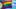 Interinklusive Regenbogenflagge vor blauem, leicht bewölktem Himmel 
